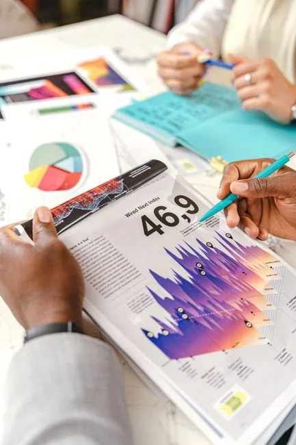 Équipe examinant des graphiques financiers et des données numériques sur des tablettes dans un environnement de bureau.